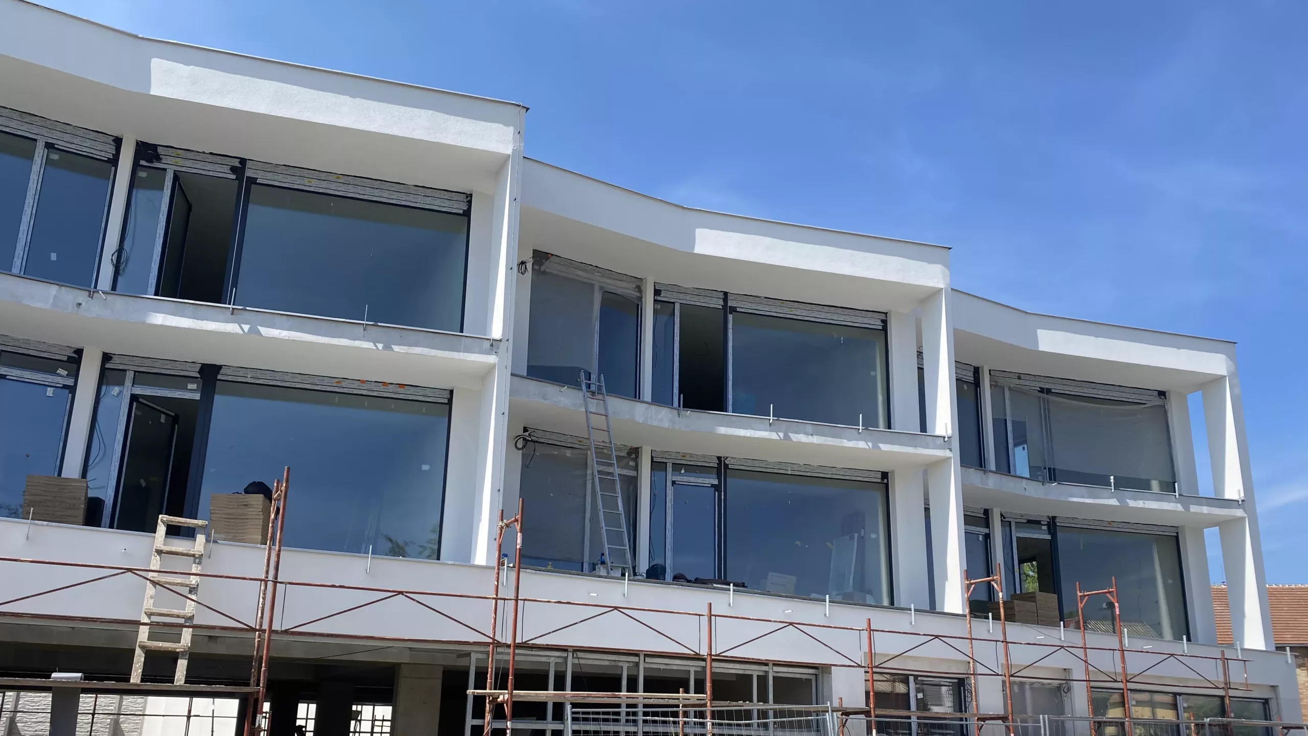 Uliční pohled na právě dokončovanou novostavbu bytového domu Zlatý potok ve Šlapanicích s byty na prodej a pronájem.